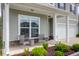 Inviting front porch with stylish seating area, manicured landscaping, and a charming entryway with a decorative wreath at 114 W Bradford Pointe Dr, Summerville, SC 29483
