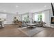 Open-concept living room with modern decor, large windows with sheer curtains, and a seamless transition to the dining area at 114 W Bradford Pointe Dr, Summerville, SC 29483