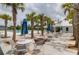 Community pool area with tables, lounge chairs, palm trees and building in the background at 114 W Bradford Pointe Dr, Summerville, SC 29483