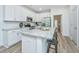 Stylish kitchen island featuring granite countertops, stainless steel appliances, modern white cabinets, and sleek barstool seating at 1204 Twin Rivers Drive, Wando, SC 29492