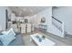Open-concept living room featuring modern decor, a dining area, a staircase, and stylish gray hardwood floors at 1204 Twin Rivers Drive, Wando, SC 29492