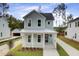 Charming two-story home featuring a welcoming front porch, light blue siding, and a well-manicured lawn at 126 Maritime Way, Summerville, SC 29485