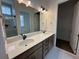 Dual sink bathroom vanity with granite countertops and a large mirror with decorative lighting at 139 Summerwind Dr, Summerville, SC 29486