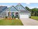 Charming single-story home featuring a two-car garage, blue siding, and a well-manicured front lawn at 139 Summerwind Dr, Summerville, SC 29486
