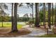 A stone path through the trees, lined with benches and leading to a beautiful pond at 1425 Clay Field Trl, Summerville, SC 29485
