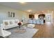 Open concept living room showing hardwood floors, modern furniture, and a view of the kitchen and breakfast bar at 157 Threaded Fern St, Summerville, SC 29485