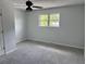 A bedroom with gray carpet and walls features a ceiling fan and a window at 1735 Boone Hall Dr # K6, Charleston, SC 29407