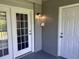 Exterior entry door and glass-paneled french doors with a wall lamp above the french doors at 1735 Boone Hall Dr # K6, Charleston, SC 29407
