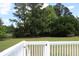 A backyard view from the deck, showing chain link fence framed by lush greenery and mature trees at 18808 Round O Rd, Round O, SC 29474
