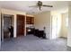 Large room with carpet, ceiling fan, doorway to another room, shelving and a closet at 18808 Round O Rd, Round O, SC 29474