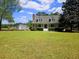 Charming two-story home with a red front door, front porch and storage shed on large lot at 18808 Round O Rd, Round O, SC 29474