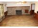 Open living room featuring hardwood flooring, a brick fireplace, and traditional design elements at 18808 Round O Rd, Round O, SC 29474