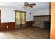 Spacious living room with hardwood floors, brick fireplace, and wood paneled walls at 18808 Round O Rd, Round O, SC 29474