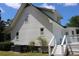 The side of this beautiful two-story home features white siding, a back deck, and manicured landscaping at 18808 Round O Rd, Round O, SC 29474