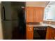 Galley kitchen showing the black refrigerator, stainless counters, and built-in dishwasher at 192 Ashley Ave # C, Charleston, SC 29403