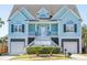 Charming blue two-story beach house with elevated entry, white trim, and two-car garage at 2107 Club View Ct, Charleston, SC 29412