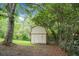 Storage shed in a backyard surrounded by trees, offering ample space for tools and outdoor equipment at 211 Bramblewood Dr, Summerville, SC 29485