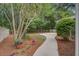 Landscaped backyard with a paved path, mature trees, and various plants, creating a tranquil outdoor space at 2154 Country Manor Dr Dr, Mount Pleasant, SC 29466