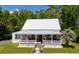 Inviting white home with metal roof, front porch, and meticulously maintained lawn at 21785 Lowcountry Hwy, Ruffin, SC 29475