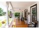 Inviting front porch featuring classic white columns, wood flooring, an American flag, and tasteful decorations at 21785 Lowcountry Hwy, Ruffin, SC 29475