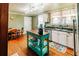 Kitchen with wood floors, stainless steel appliances, island table, and view into the dining area at 21785 Lowcountry Hwy, Ruffin, SC 29475