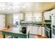 Bright kitchen with stainless steel appliances, black countertops, island table, and colorful window curtains at 21785 Lowcountry Hwy, Ruffin, SC 29475