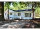 This charming white house boasts a covered porch, mature trees, and a large front yard at 227 Amy Dr, Goose Creek, SC 29445