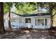 Charming white home with a dark roof, a covered porch, and mature trees in the front yard at 227 Amy Dr, Goose Creek, SC 29445