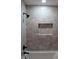 This tiled shower includes updated fixtures, a sleek shower head, and a recessed shelf at 227 Amy Dr, Goose Creek, SC 29445