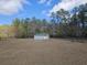Exterior shot of metal outbuilding surrounded by trees on an open lot at 2300 Bethera Rd # B, Bonneau, SC 29431
