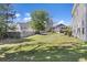 Grassy backyard shows landscaping, fencing, and neighboring homes under a blue sky at 254 Cypress Marsh Rd, Moncks Corner, SC 29461