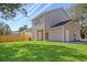 Large backyard featuring green grass, a wooden fence, and a view of the home's exterior at 2606 Bennett Yard Rd, North Charleston, SC 29405