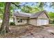 Charming single-story home with attached garage, surrounded by mature trees and a well-maintained lawn at 2919 Fernwood Dr, North Charleston, SC 29406