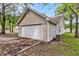 Side view of the attached garage with a driveway, siding, and well-kept landscape around the house at 2919 Fernwood Dr, North Charleston, SC 29406