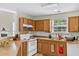 Functional kitchen with wooden cabinets, a white oven, and a view of the living room at 2919 Fernwood Dr, North Charleston, SC 29406