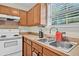 This bright kitchen features an oven, double basin sink, oak cabinets, and a window offering lots of natural light at 2919 Fernwood Dr, North Charleston, SC 29406