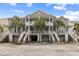 Charming two-story townhome featuring dual balconies, private garages, and tropical landscaping with palm trees at 3019 Fraserburgh Way, Mount Pleasant, SC 29466