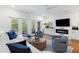 Bright living room featuring a fireplace, white cabinets, and hardwood flooring at 3019 Fraserburgh Way, Mount Pleasant, SC 29466