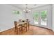 Cozy dining area features hardwood floors, natural light, and a charming chandelier at 3084 Queensgate Way, Mount Pleasant, SC 29466