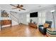 Bright living room with wood floors, staircase, and lots of natural light at 3084 Queensgate Way, Mount Pleasant, SC 29466