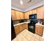 Well-equipped kitchen featuring sleek black appliances, light wood cabinets, and stylish backsplash at 310 Flyway Rd, Goose Creek, SC 29445