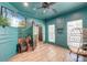Stylish bedroom with unique turquoise walls, wood-look floors, a ceiling fan and ample natural light at 3298 Heathland Way, Mount Pleasant, SC 29466