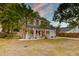 Two-story home featuring covered front porch, neutral siding, green lawn, and trees at 3298 Heathland Way, Mount Pleasant, SC 29466