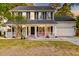 Two-story home with a welcoming covered porch, white trim, dark shutters and an attached garage at 3298 Heathland Way, Mount Pleasant, SC 29466