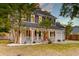 Charming home featuring a cozy front porch, mature trees, and a well-manicured lawn at 3298 Heathland Way, Mount Pleasant, SC 29466