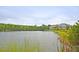Scenic view of a serene pond with lush greenery and a glimpse of nearby buildings at 3298 Heathland Way, Mount Pleasant, SC 29466