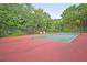 Outdoor tennis court surrounded by mature landscaping, offers a private sports and recreation amenity at 3298 Heathland Way, Mount Pleasant, SC 29466
