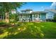 Beautiful backyard with lush green lawn and a charming blue house in the background at 3769 Maidstone Dr, Mount Pleasant, SC 29466