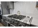 Close-up of a stainless steel gas range with cooktop, white tile backsplash, and kettle at 424 Carrara Dr, Summerville, SC 29486