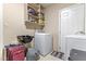 Laundry room with a sink, washing machine, shelving, and beige tile flooring at 4407 S Shirley Dr, North Charleston, SC 29418